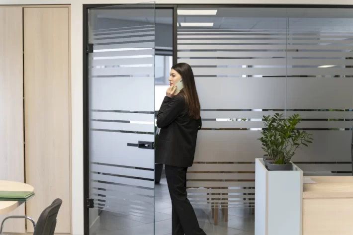 kobieta rozmawiająca przez telefon, przy ściance działowej